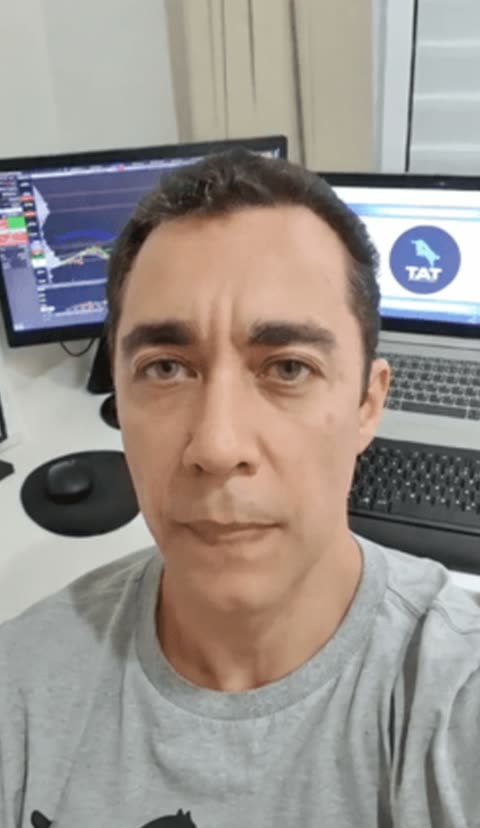 Membro da comunidade em frente aos monitores de trading